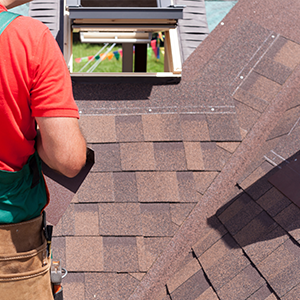 Roofer working on a red shingle roof